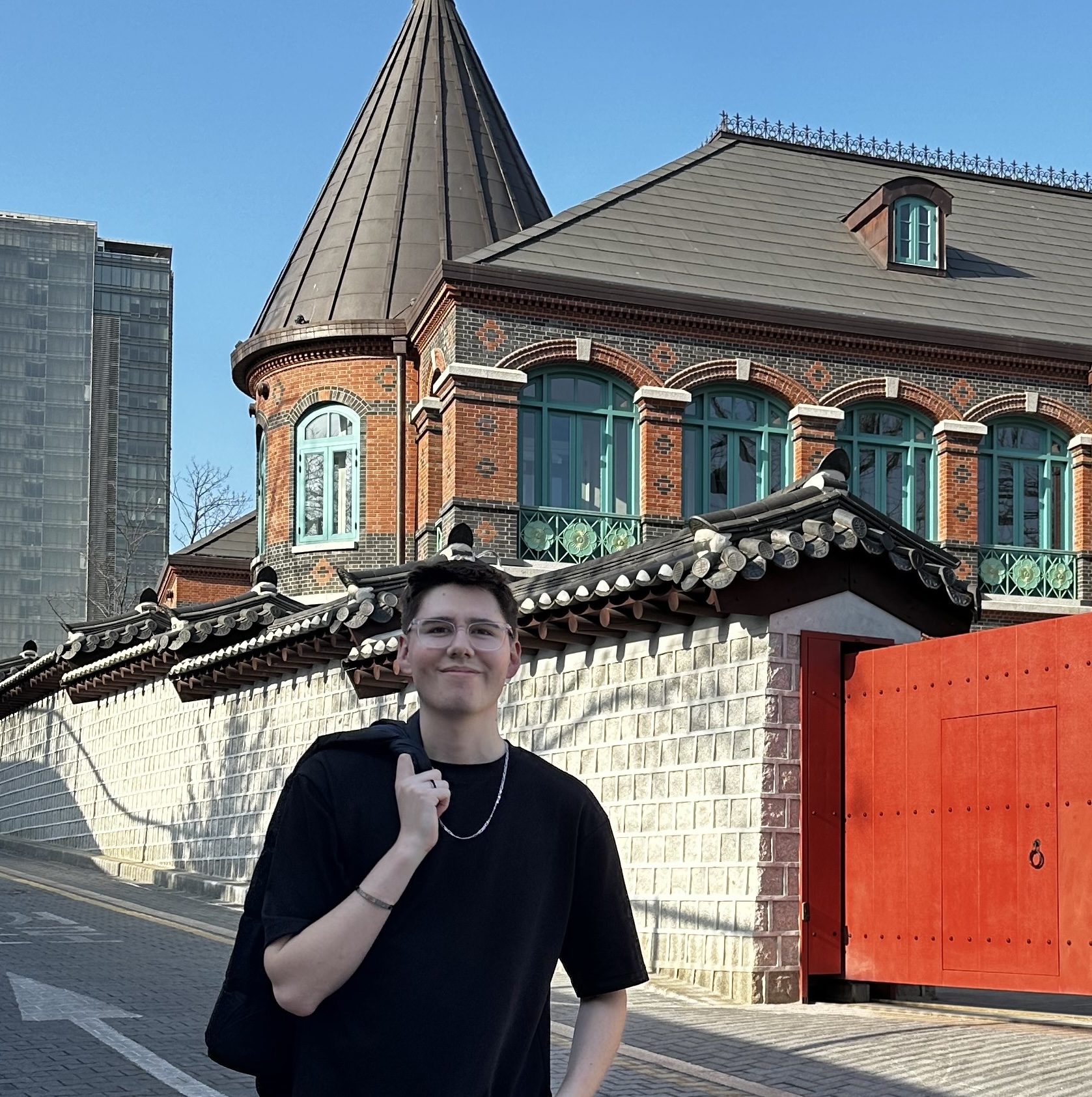 A photo of Josh Henderson in front of a Korean building in Seoul.